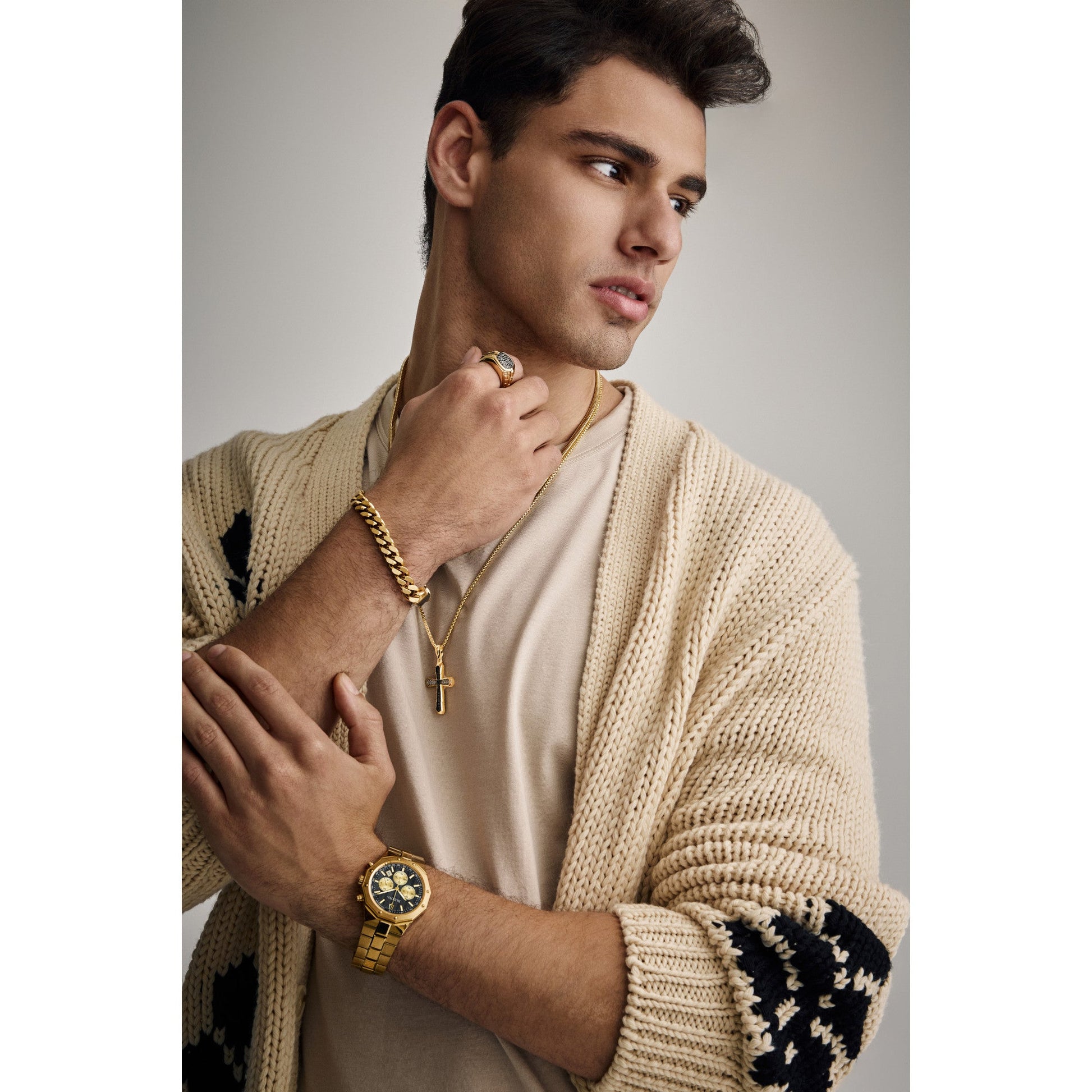 Bulova BVR1013-YSAAA worn on finger, showing its substantial presence, gold-tone luster, and contrasting black-diamond centerpiece under ambient light.