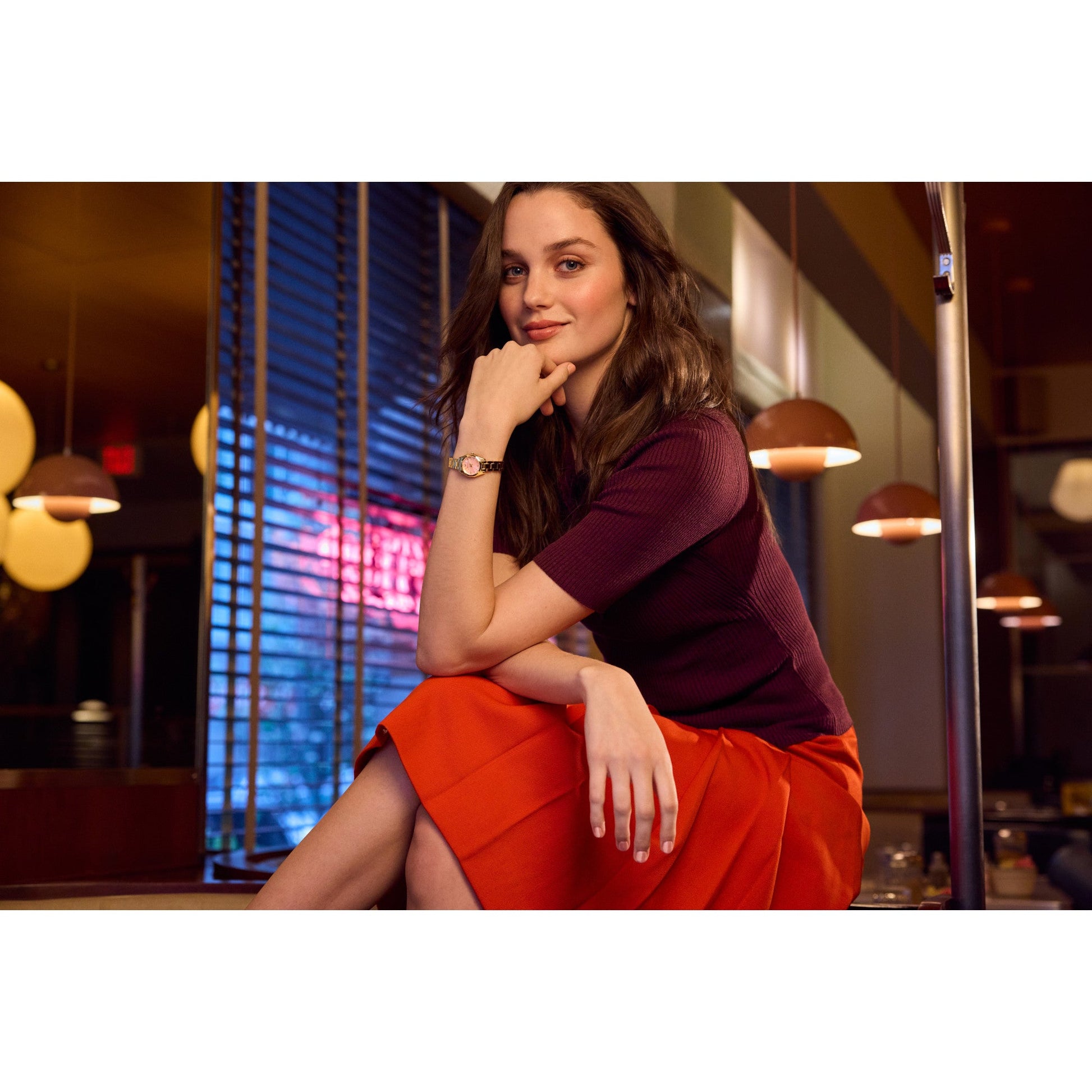 Model wearing Bulova 97L187, showcasing the pink dial and gold-tone bracelet in a lifestyle setting.