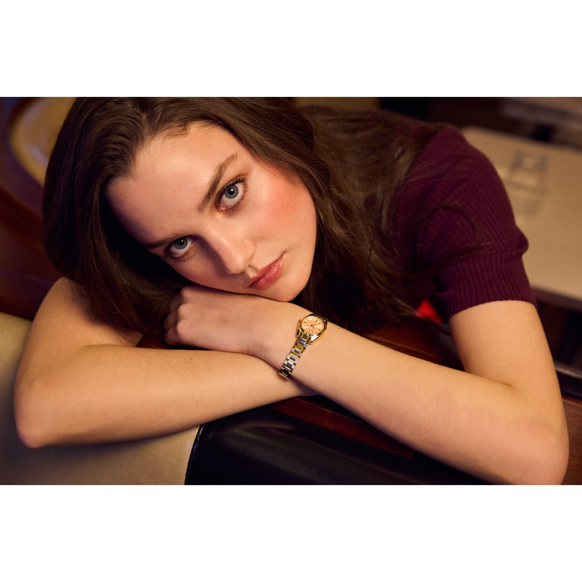 Model wearing Bulova 97L187, showcasing the pink dial and gold-tone bracelet in a lifestyle setting.