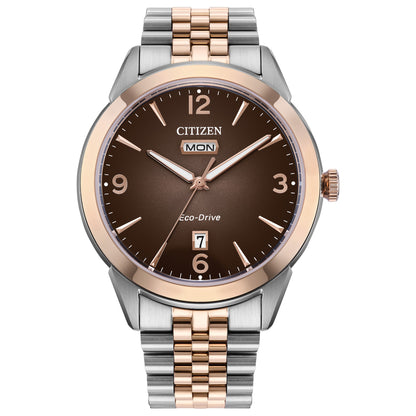 Citizen AW0156-57X front view featuring a 40.5 mm two-tone stainless steel case (silver and rose gold), brown gradient dial with rose-gold Arabic numerals, day window at 12 o’clock and date window at 6 o’clock.