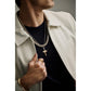Model wearing Bulova BVP1156-WYSNA around the neck — cross pendant resting at mid-chest over a shirt, showing scale and two-tone finish.