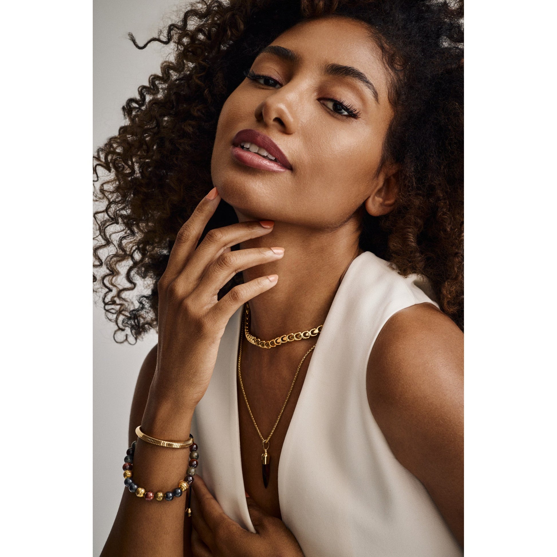 Bracelet BVB1203-YSNA worn on wrist, displaying its gold-tone snake-chain links elegantly wrapped around the wrist under soft lighting.