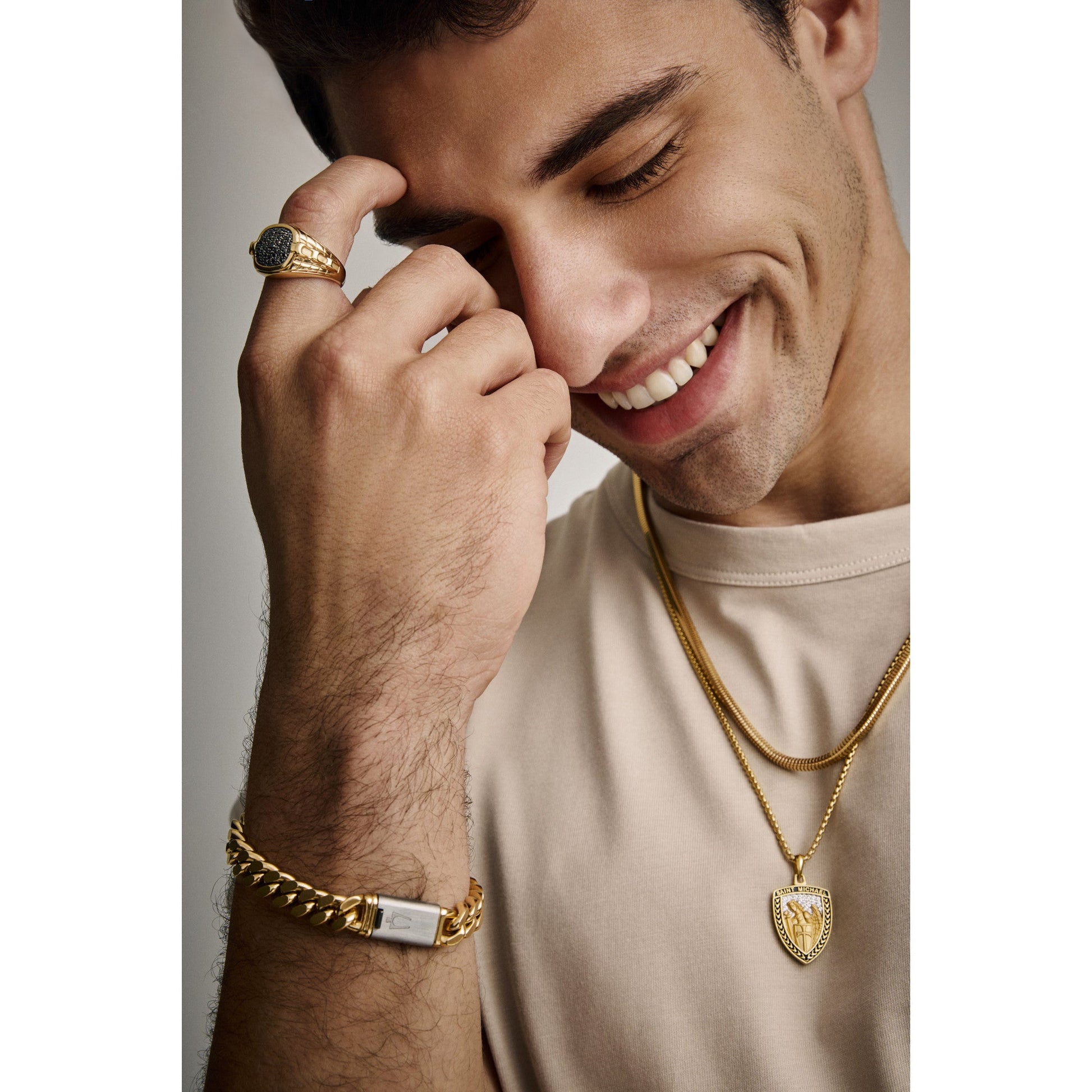 Bulova BVR1013-YSAAA worn on finger, showing its substantial presence, gold-tone luster, and contrasting black-diamond centerpiece under ambient light.