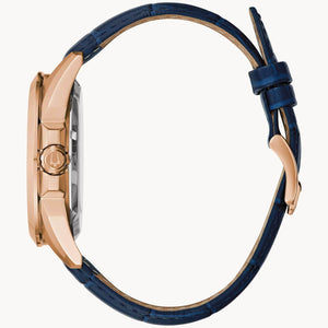 Side profile of the Bulova 97A161, highlighting the rose gold-tone stainless steel case and the blue alligator-textured leather strap.
